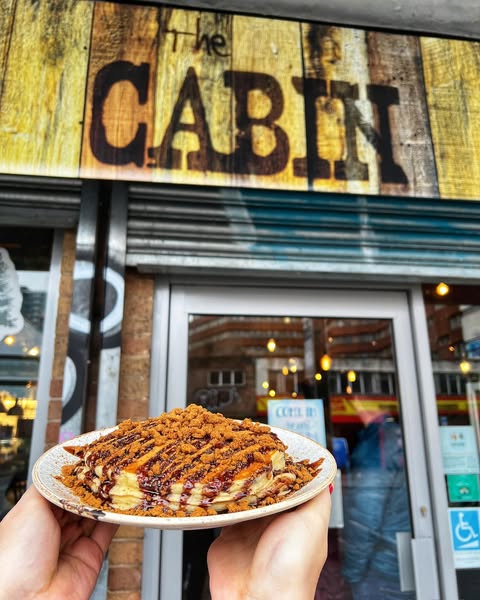 Biscoff pancake stack pictured in front of The Cabin welcome sign. Best Places for Brunch in Sheffield.