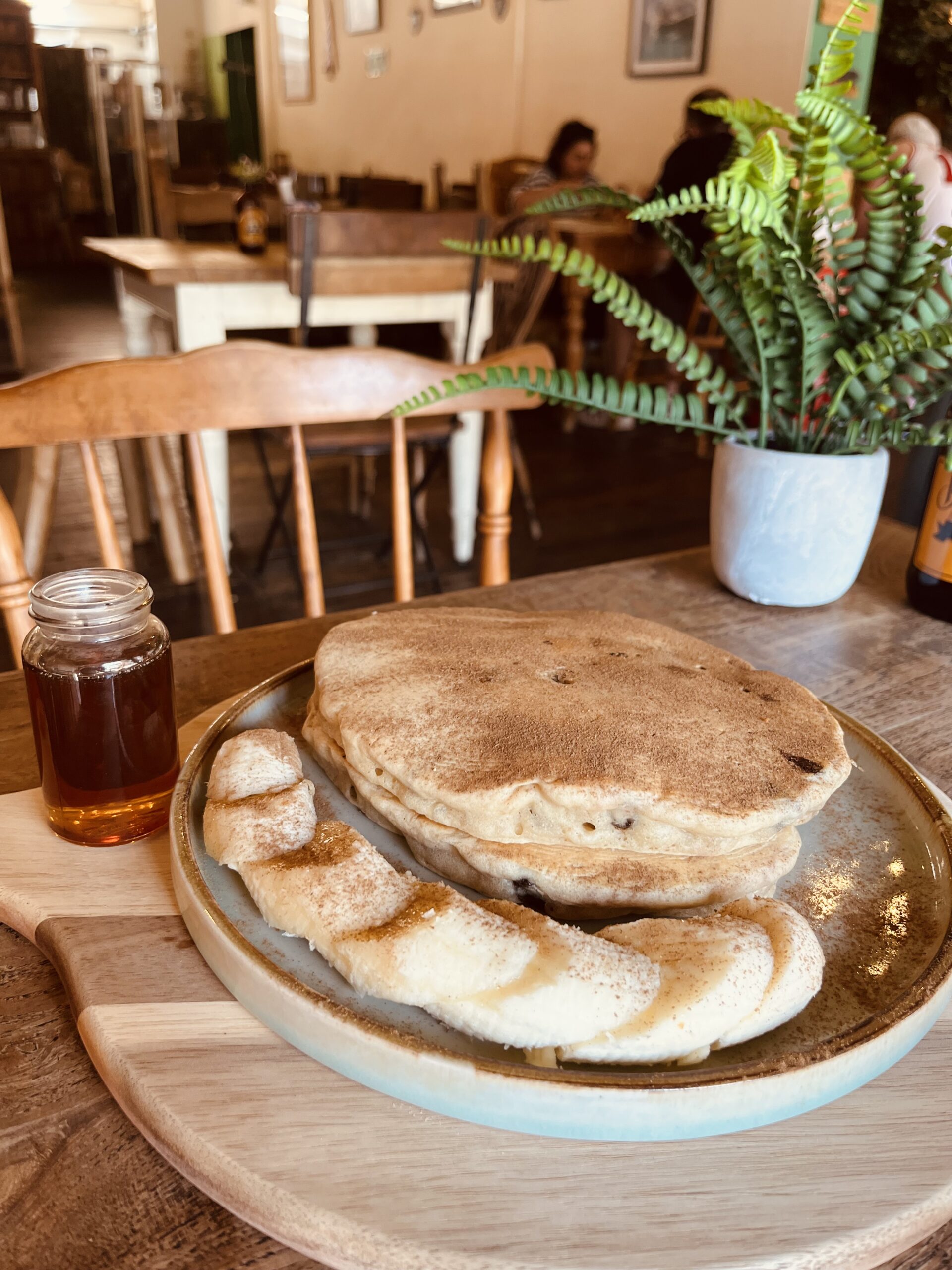 Vegan banana bread pancakes stacked high and drizzled with maple syrup, served at The Cabin in Sheffield.